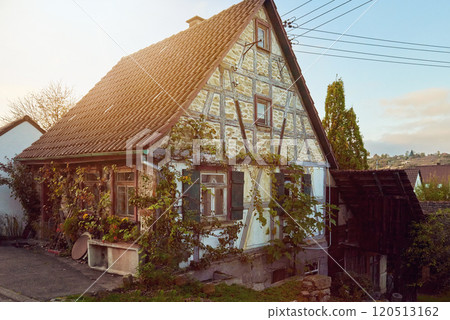 Charming Vintage Half-Timbered House Surrounded by Lush Greenery in Rural Baden-Wurttemberg, Germany. A Serene Sunset Scene. This Charming Vintage House is Beautifully Surrounded by Lush Greenery 120513162