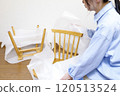 一位女士打開了一張她在網路上購買的椅子 120513524