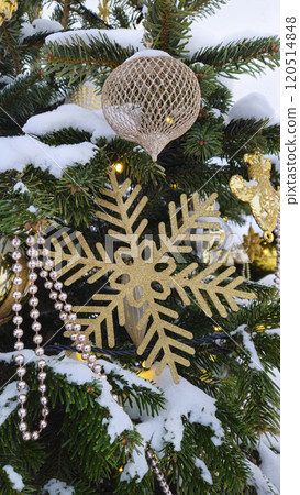 Branches of Christmas tree with beautiful decorations covered with snow Branches of Christmas tree with beautiful decorations covered with snow 120514848