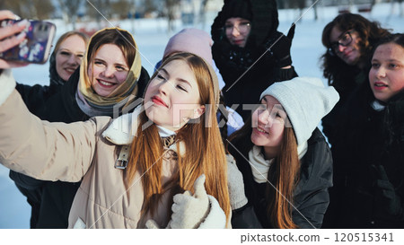 Schoolgirls having fun and taking selfies in a winter park on their day off 120515341
