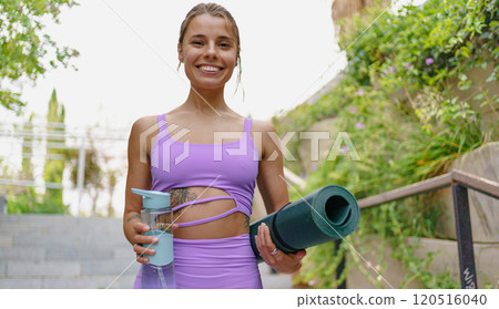 An Active Woman Engaging in Yoga Practice Outdoors with a Mat and a Water Bottle in Nature An Active Woman Engaging in Yoga Practice Outdoors with a Mat and a Water Bottle in Nature 120516040