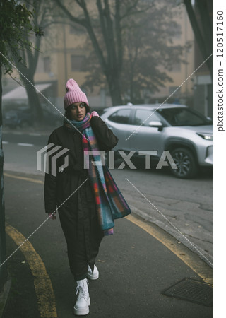 A woman in a stylish pink hat and scarf walks gracefully down the street A woman in a stylish pink hat and scarf walks gracefully down the street 120517160