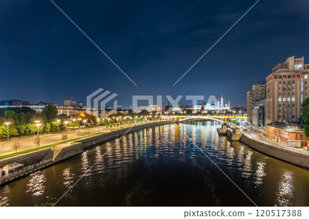 Illuminated Moscow Kremlin and Bolshoy Kamenny Bridge at summer night. View from the Patriarshy pedestrian Bridge 120517388
