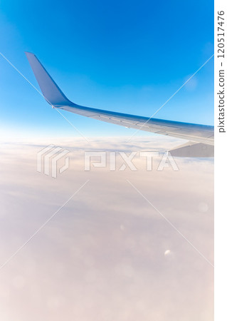 View from the airplane window at a beautiful cloudy sky and the airplane wing View from the airplane window at a beautiful cloudy sky and the airplane wing 120517476