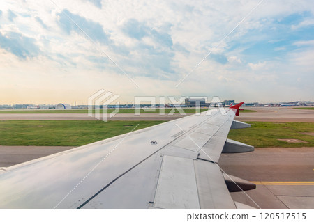 View of airplane wing, blue skies and green land during landing. Airplane window view. View of airplane wing, blue skies and green land during landing. Airplane window view. 120517515