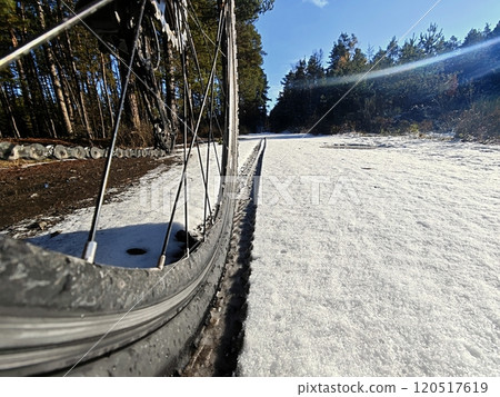 Rear wheel of mountain bicycle in snowy meadow in the countryside Rear wheel of mountain bicycle in snowy meadow in the countryside 120517619