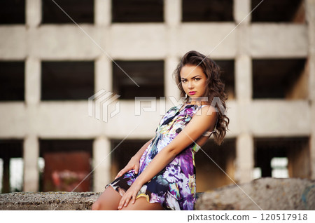 Portrait of a beautiful model posing in evening light measure concrete wall 120517918