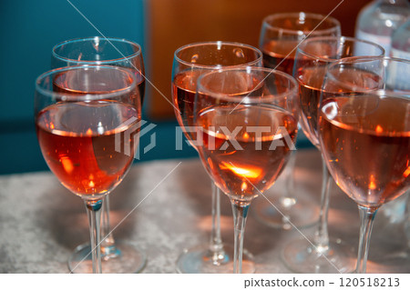 Glass goblets filled with rose wine closeup. Glass goblets filled with rose wine closeup. 120518213
