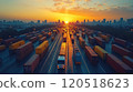 Trucks and containers fill the highway under a vibrant sunset in a bustling urban landscape 120518623