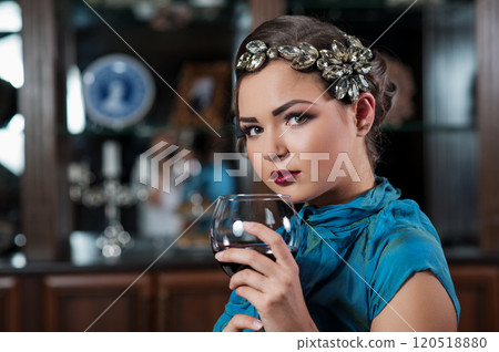 young brown-haired girl is drinking and tasting a glass red dry wine young brown-haired girl is drinking and tasting a glass red dry wine 120518880