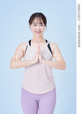 Woman doing yoga pose with hands together 120519082