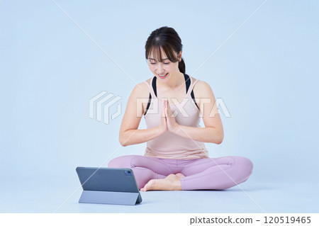 A woman in sportswear looking at a tablet PC screen 120519465