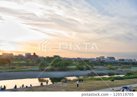 Children playing on the riverbank at dusk 120519705
