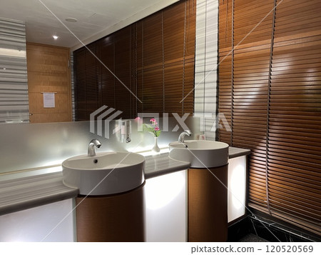 Clean new public bathroom with white washbasin and taps. Public restroom interior. 120520569