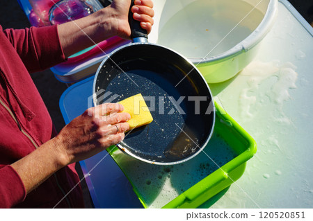 Woman washing dishes in bowl, capming outdoor Woman washing dishes in bowl, capming outdoor 120520851