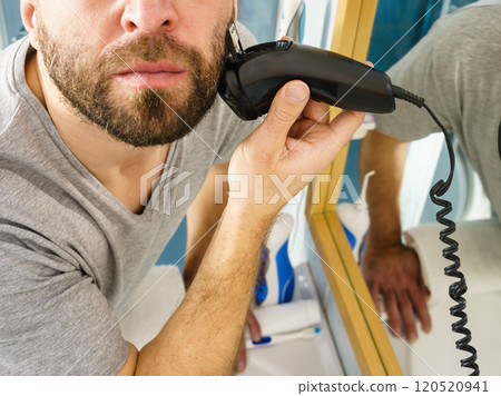 Man shaving trimming his beard Man shaving trimming his beard 120520941