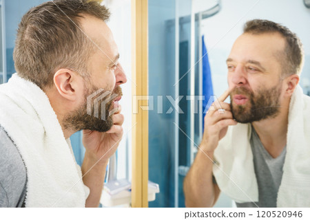 Man looking at his beard in mirror 120520946