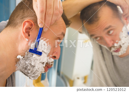 Guy shaving his beard in bathroom Guy shaving his beard in bathroom 120521012
