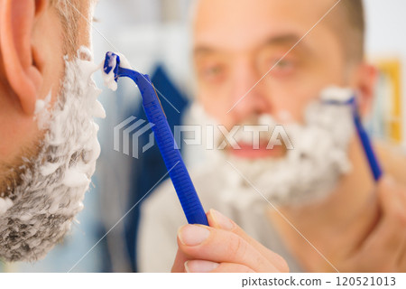 Guy shaving his beard in bathroom 120521013