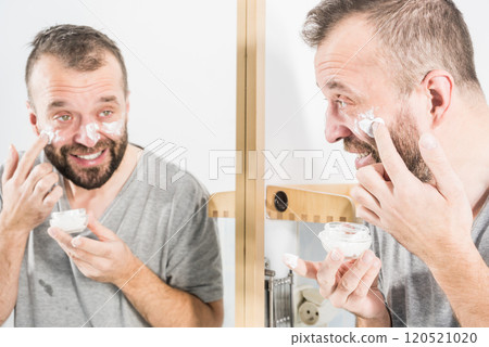 Man applying moisturizer cream in bathroom Man applying moisturizer cream in bathroom 120521020