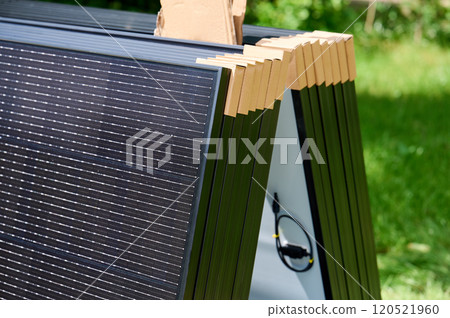 Close-up new solar panels with protective cardboard corners, ready for installation. Renewable energy technology, green living, and the implementation of solar power in residential areas. Close-up new solar panels with protective cardboard corners, ready for installation. Renewable energy technology, green living, and the implementation of solar power in residential areas. 120521960