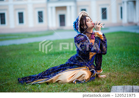 Beautiful girl in a vintage blue dress drinks wine. Beautiful girl in a vintage blue dress drinks wine. 120521975