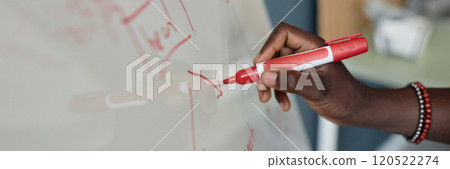 Close-up view of hand holding red marker and writing on whiteboard during a presentation in classroom environment detailed diagrams being sketched on board 120522274