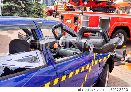 Emergency response demonstration using tools on a blue vehicle in a city setting 120522850