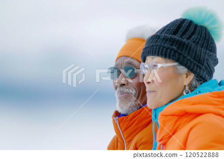 close-up portrait of spouses in warm down jackets and hats against the sea during walk by the ocean in winter, concept of active old age and mother's day 120522888
