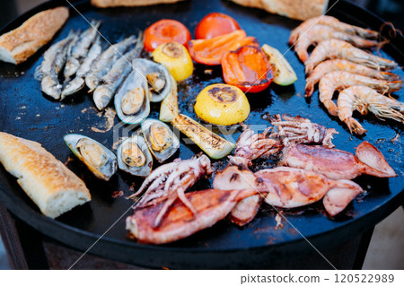 Grilled seafood and vegetables on a skillet, perfect for summer BBQ and outdoor dining inspiration 120522989
