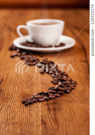 Coffee beans, a cup of fragrant coffee on a wooden background. 120523274