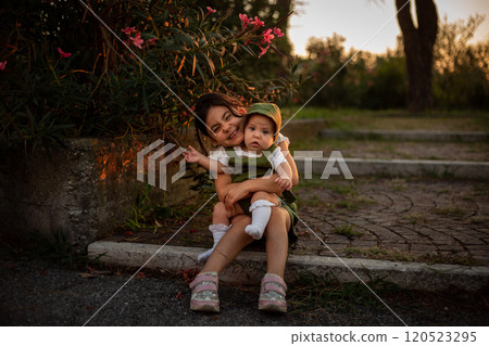 portrait of two children, sitting on the stairs in the park 120523295