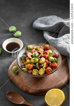 Fried brussels sprouts with nuts in soy sauce on a dark background. Concept nutritious asian dish Fried brussels sprouts with nuts in soy sauce on a dark background. Concept nutritious asian dish 120523843