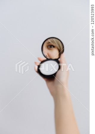 Focused eye reflection in a compact mirror held against a minimal background 120523993