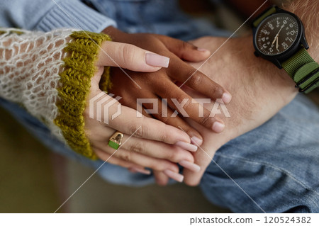 Cropped shot of adoptive mother and father holding hands with little Black boy giving kid feeling of love and safety at home 120524382
