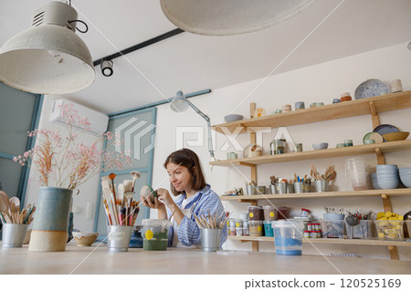 Creative and talented Artist working in a Bright Clay Studio filled with Pottery Supplies 120525169
