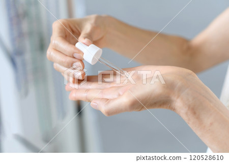一名中年婦女在手上塗抹血清的手 120528610
