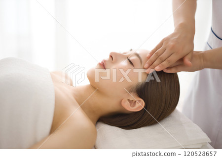Woman receiving a massage from an esthetician Woman receiving a massage from an esthetician 120528657