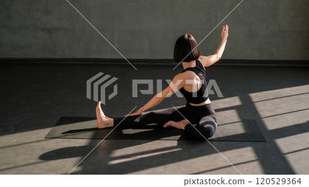 Pilates session. Fitness workout. Athletic woman stretching body muscle flexibility performing physical exercise on mat in gym studio indoors. 120529364
