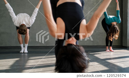 Yoga workout. Pilates exercise. Unrecognizable people group lesson practice stretch training asana pose gymnastic with female sport instructor in fitness studio indoors. 120529374