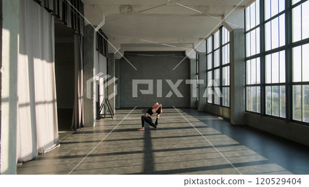 Pilates training. Balance exercise. Athletic woman in activewear practice sport yoga pose gymnastic workout muscle stretch in gym fitness studio loft interior. 120529404