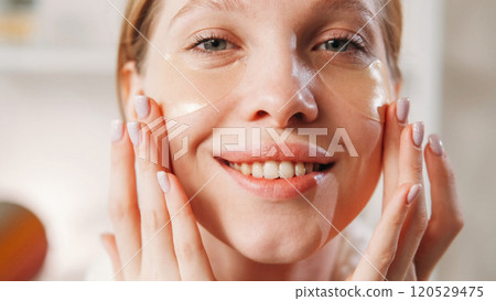 Skin breathe. Moisturizing face. Young smiling girl with natural makeup healthy fresh skin applying collagen hydrogel eye patches. 120529475