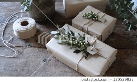 Beautifully wrapped gifts with natural decorations on wooden table 120529922