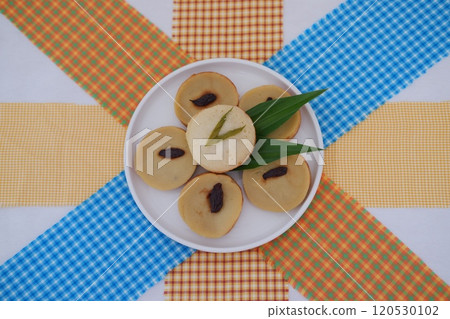 Kue Lumpur or Mud Cake, Indonesian traditional cake made from potato, flour, eggs and coconut milk topped with raisins served on white plate. beautiful decoration 120530102