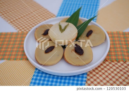 Kue Lumpur or Mud Cake, Indonesian traditional cake made from potato, flour, eggs and coconut milk topped with raisins served on white plate. beautiful decoration 120530103