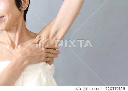 Middle-aged Asian woman holding her armpits Middle-aged Asian woman holding her armpits 120530126
