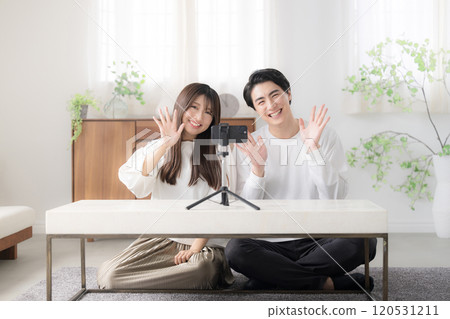 一對男女正在播放視頻，揮手打招呼，從廣角看鏡頭 120531211