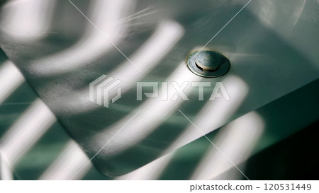 The bathroom sink and the sunlight coming through the blinds 120531449