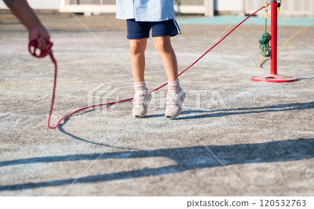 Nursery school girl jumping rope 120532763
