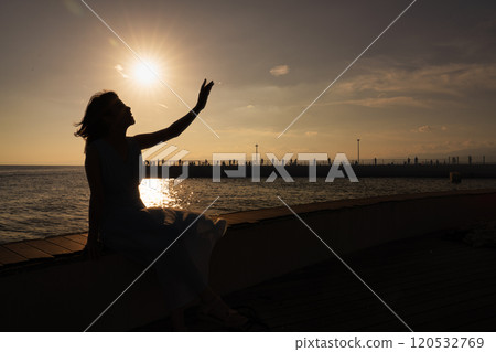 Woman watching the sunset at the harbor Woman watching the sunset at the harbor 120532769